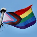 Un drapeau LGBTQ+ flotte au vent.