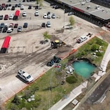 An aerial view of the spot where the 'catastrophic' water main rupture broke ground, next to a plaza on 16th Avenue N.W., just west of Home Road. 