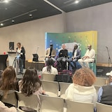 Alain Tshinza, Merouane Abed, Jean Kabongo et Patrick Tshiovo assis devant une assistance.