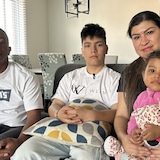 Les quatre membres de la famille sont assis sur le divan. 