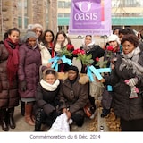 Un groupe d'une dizaine de femmes, toute origine confondue, certaines roses en main sourient à la caméra. Certaines sont debout, d'autres accroupies. En arrière-plan, une bannière de Oasis centre des femmes est plantés avec la légende : Nous sommes là pour vous.