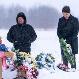 From left to right, Peter Chapman Band Chief Robert Head, James Smith Cree Nation Chief Wally Burns and Prime Minister Justin Trudeau stand in front of a grave of one of the victims of the mass stabbing incident at James Smith Cree Nation, Sask., on Monday.