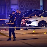 Toronto police are pictured at the scene of a fatal shooting in the parking lot of an Etobicoke high school late Sunday.
