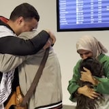 Ossama Zaqqout, left, embraces his father at the Calgary International Airport on Saturday, April 28. His Mother, right, hugs another family member.