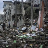 فلسطينيون يراقبون الأضرار الناجمة عن غارة إسرائيلية على مدينة رفح جنوبيّ قطاع غزة في 27 كانون الثاني (يناير) 2024.