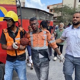 An injured man escorted by Palestinian Medics after Israeli airstrikes on Gaza hospital kill at least 19 people, including 5 journalists.