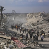 فلسطينيون يسيرون وسط دمار الحرب في مدينة خان يونس في قطاع غزة في كانون الثاني (يناير) 2025.