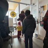 Des personnes font la file dans un bureau de vote.