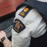 Un gros plan sur l'écusson d'un agent de la GRC qui travaille à son bureau.