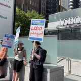 Des travailleurs de la LCBO en manifestation devant une succursale de la LCBO.