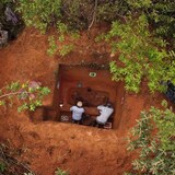 Vista aérea de dos hombres en el fondo de un agujero en una excavación forestal.