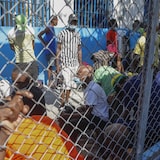 Des prisonniers derrière une clôture.