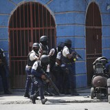Police officers take cover during an anti-gang operation in the Lalue neighborhood of Port-au-Prince, Haiti, on March 3, 2023. (Odelyn Joseph/The Associated Press)

