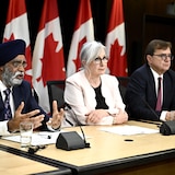 Quatre ministres assis à une table en conférence de presse