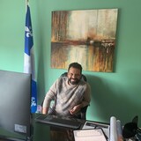 هارون بوعزّي على كرسي وراء مكتبه في دائرة موريس ريشارد في شرق مدينة مونتريال.