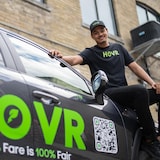 Harrison Amit, CEO of the new ride-hailing app Hovr, hopes to compete with Uber and Lyft and win over drivers with a different pay structure. Here he poses with the company's promotional car. 