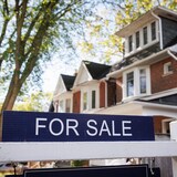 A For Sale sign sits in front of a Toronto home on July 6, 2022. February home sales dipped 3.1 per cent while home prices stayed flat from the previous month, according to the Canadian Real Estate Association.