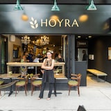 Tanya Matkivska sourit avec les bras croisés devant son restaurant.