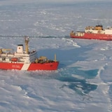 Two icebreakers break through the ice. 