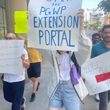 Plakard hawak ng isang nagprotesta na may nakasulat na 'Open Extension Portal.'