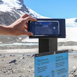 A cellphone stand with a smartphone on it pointing to a glacier ahead.