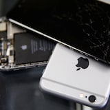 Des iPhone Apple endommagés exposés dans un atelier de réparation.