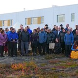 Les gens posent dehors, devant le centre Isuarsivik. 