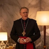 Une homme est habillé en cardinal.