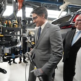 Justin Trudeau visse un boulon à l'usine de Honda à Alliston, en marge d'un point de presse, le 25 avril 2024.
