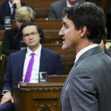 Le premier ministre Justin Trudeau et Pierre Poilievre, chef du parti conservateur du Canada en arrière-plan.