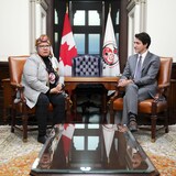 Justin Trudeau et RoseAnne Archibald assis à une table de la colline du Parlement.
