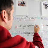 Un enseignant écrit en langue kanien'kéha (mohawk) sur un tableau blanc.