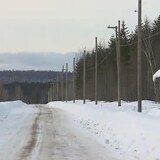 Des poteaux le long d'une route enneigée.
