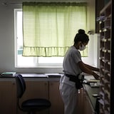 Une infirmière est en train de trier des papiers dans un bureau, aux Philippines, en mai 2025.