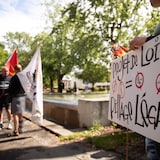 Une personne avec un pancarte contre le projet de loi 97.