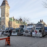Des camions stationnés l'un à côté de l'autre lors d'une manifestation près du parlement du Canada.