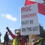 Mga nagpoprotesta na may hawak na watawat ng Iran at isang placard na nagsasabing 'IRGC terrorist must be on the list.' 
