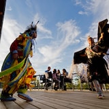 فنّانان من سكان كندا الأصليين يؤدّيان رقصة في باحة فندق ومركز مؤتمرات في مدينة ليتل كارينت (Little Current) في جزيرة مانيتولين في مقاطعة أونتاريو (أرشيف).