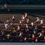 An aerial photo taken on Aug. 26, 2023, shows athletes as they compete in the women's marathon final during the World Athletics Championships in Budapest. Earlier in May, a video of a woman running the Presidente Prudente Half Marathon in Brazil went viral after her husband let her kids meet her on the course.