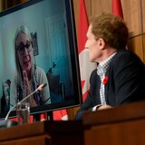 Minister of Crown-Indigenous Relations Marc Miller, right, listens as Minister of Indigenous Services Patty Hajdu, appearing via video conference at left, participates in a news conference regarding the order from the Canadian Human Rights Tribunal to compensate Indigenous children and their families on Oct. 29, 2021.