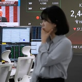 Le président américain Donald Trump apparaît sur un écran tandis qu'un cambiste travaille dans la salle des marchés de change du siège de la KEB Hana Bank à Séoul, en Corée du Sud, le jeudi 3 avril 2025.
