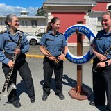 Les trois musicennes sont dehors, devant un édifice de la base navale d'Esquimalt et rigolent ensemble, le 23 juin 2022.