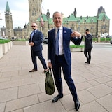 Mark Carney parle aux médias devant le parlement.