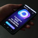 Un téléphone cellulaire dans la main d'un internaute affiche la page d'accueil de l'application Max.