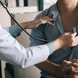 طبيب أُسرة يستخدم سماعة طبية للاستماع إلى نبضات قلب مريضه.
