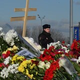 A police officer stands guard by a makeshift memorial in front of the burnt-out Crocus City Hall concert venue near Moscow, on Monday. 
