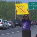 A woman holding a sign above her head during a protest.