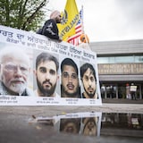 Un partisan tenant une pancarte la photo du premier ministre indien, Narendra Modi, et celles des trois accusés.