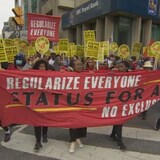 The protesters are calling on the government to create an uncapped program that would grant permanent resident status to all migrants and undocumented people without any exclusions. (Daniel Dadoun/CBC)