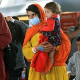 Une femme tient un enfant dans ses bras.